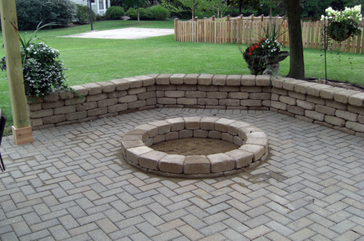 Suncraft Design Build custom circular fire pit with stone surround green lawn Columbus Ohio