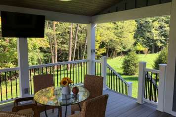 Suncraft Design Build custom open porch interior with ceiling fan wooded hillside view Columbus Ohio